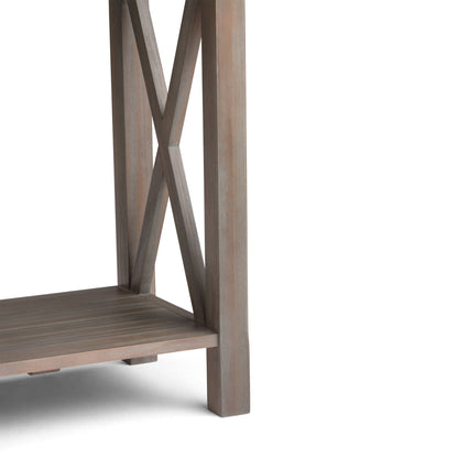 Close-up of the Kitchener - Handcrafted Table corner, showing its X-shaped side design, lower shelf, and light brown weathered finish.