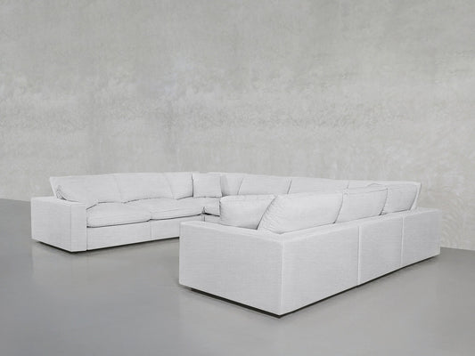 An 8-Seat Modular U-Sectional with thick cushions in light gray is placed in a minimalist room with gray floors and textured gray walls.