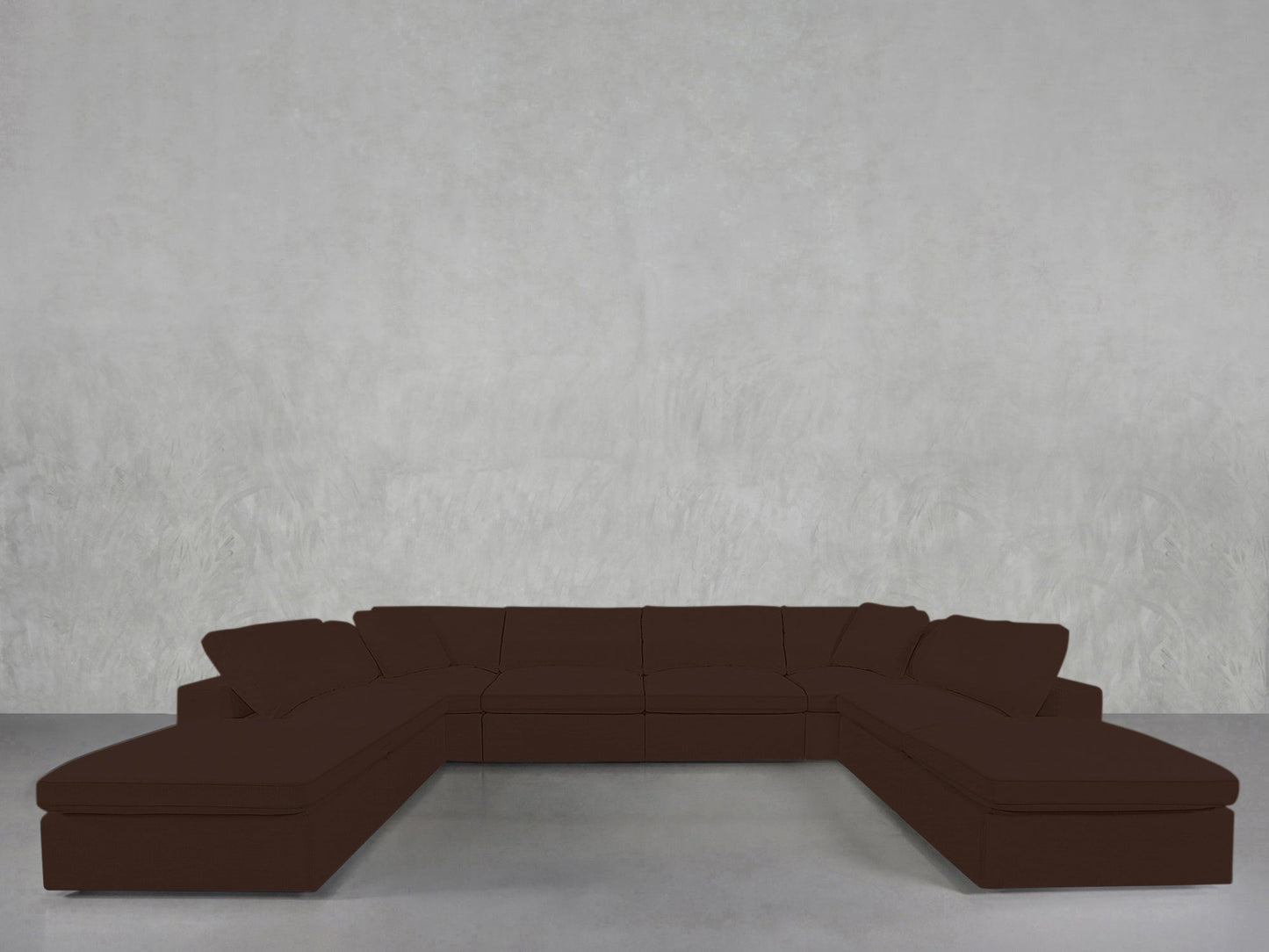 An 8-Seat Modular Double Lounger U-Sectional in dark brown is arranged against a plain, light gray textured wall atop a smooth, light gray floor.