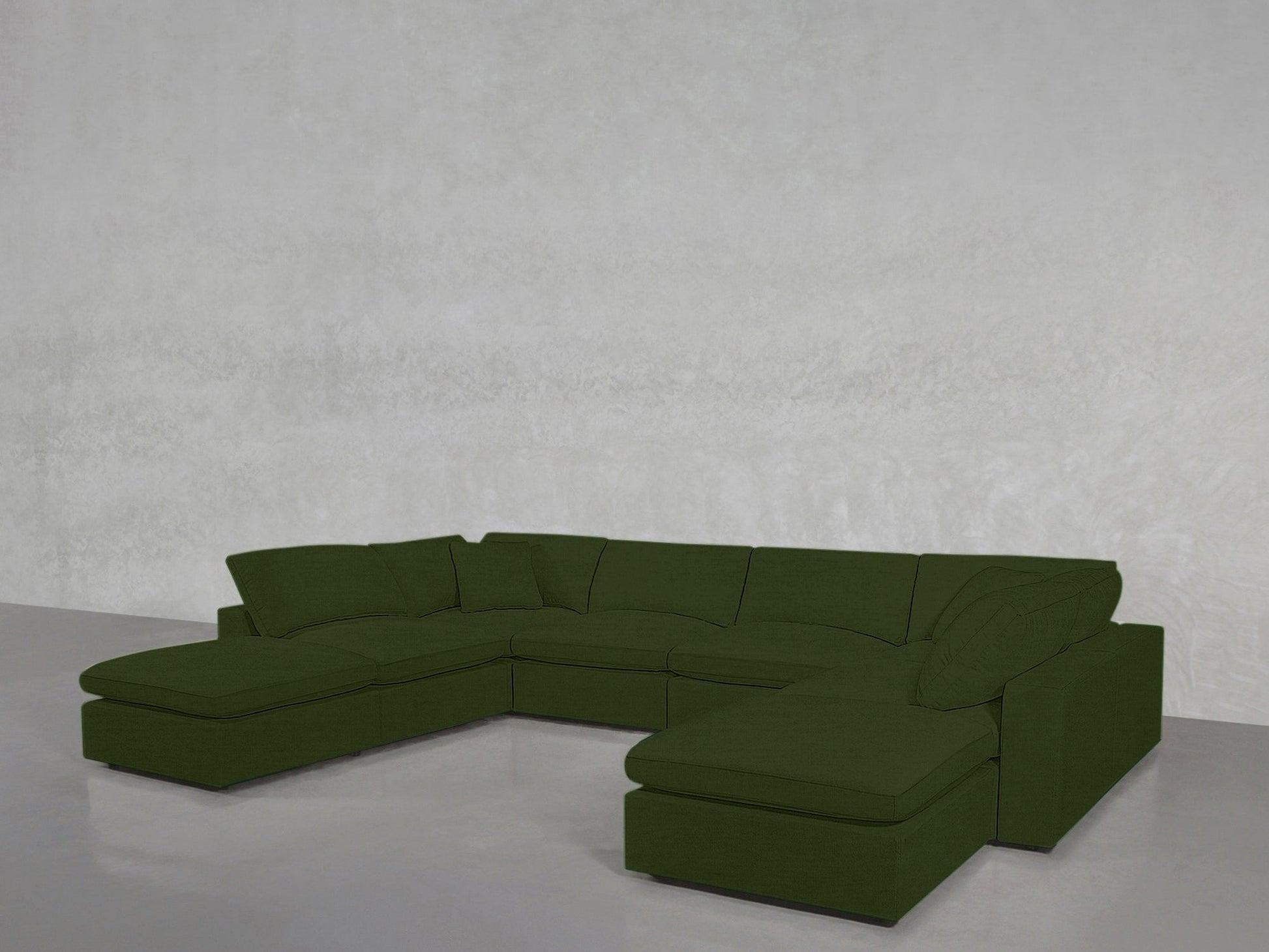 The 8-Seat Modular Double Lounger U-Sectional in dark green features a left-side chaise and right-side ottoman, set against a light gray textured wall and a smooth, light gray floor.