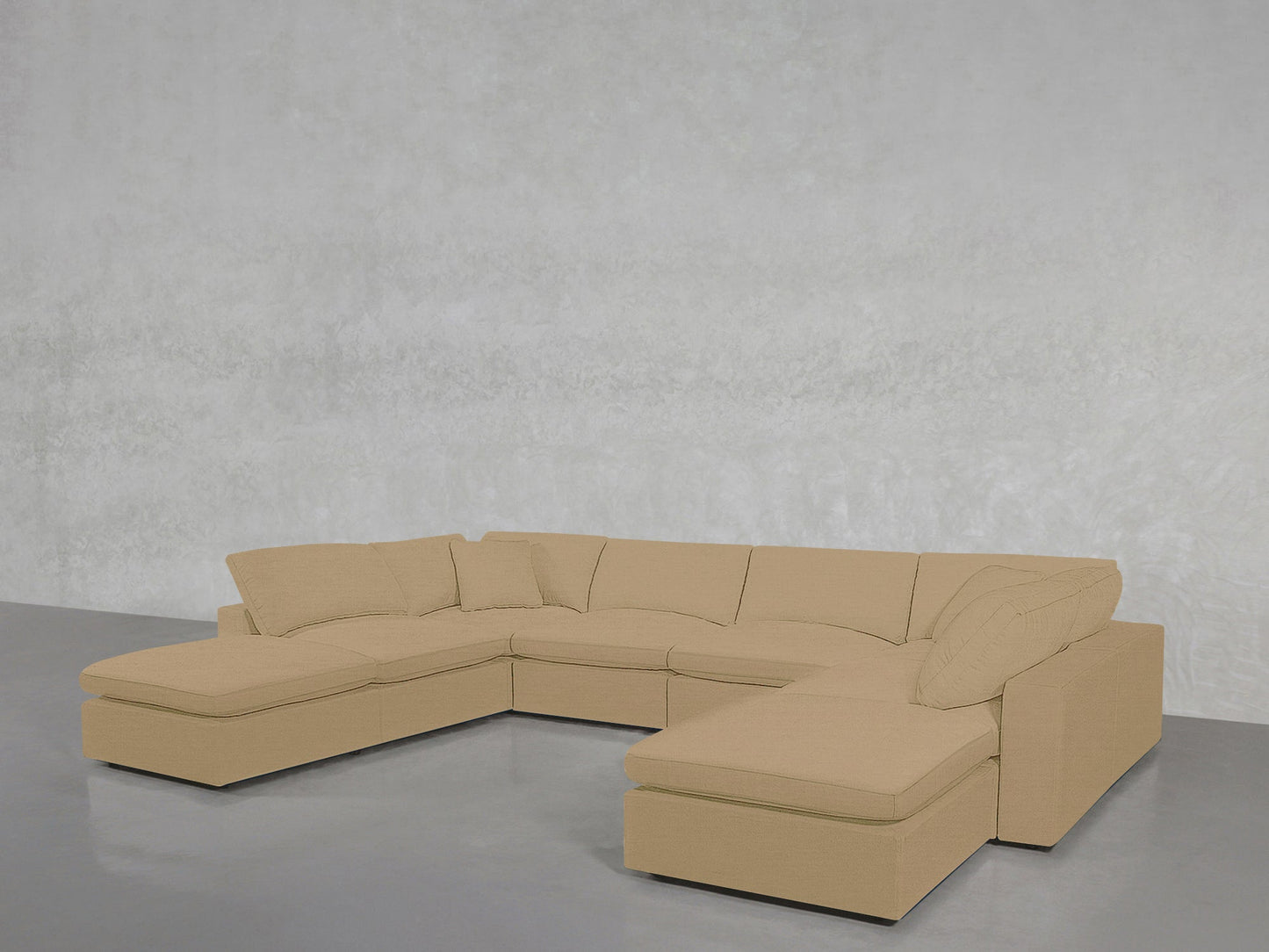 An 8-Seat Modular Double Lounger U-Sectional with plush cushions rests on a smooth gray floor, set against a light gray textured wall.