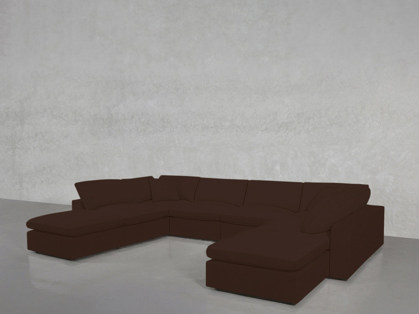 An 8-Seat Modular Double Lounger U-Sectional in dark brown sits in an empty, minimalist room with light gray walls and a smooth, light gray floor.