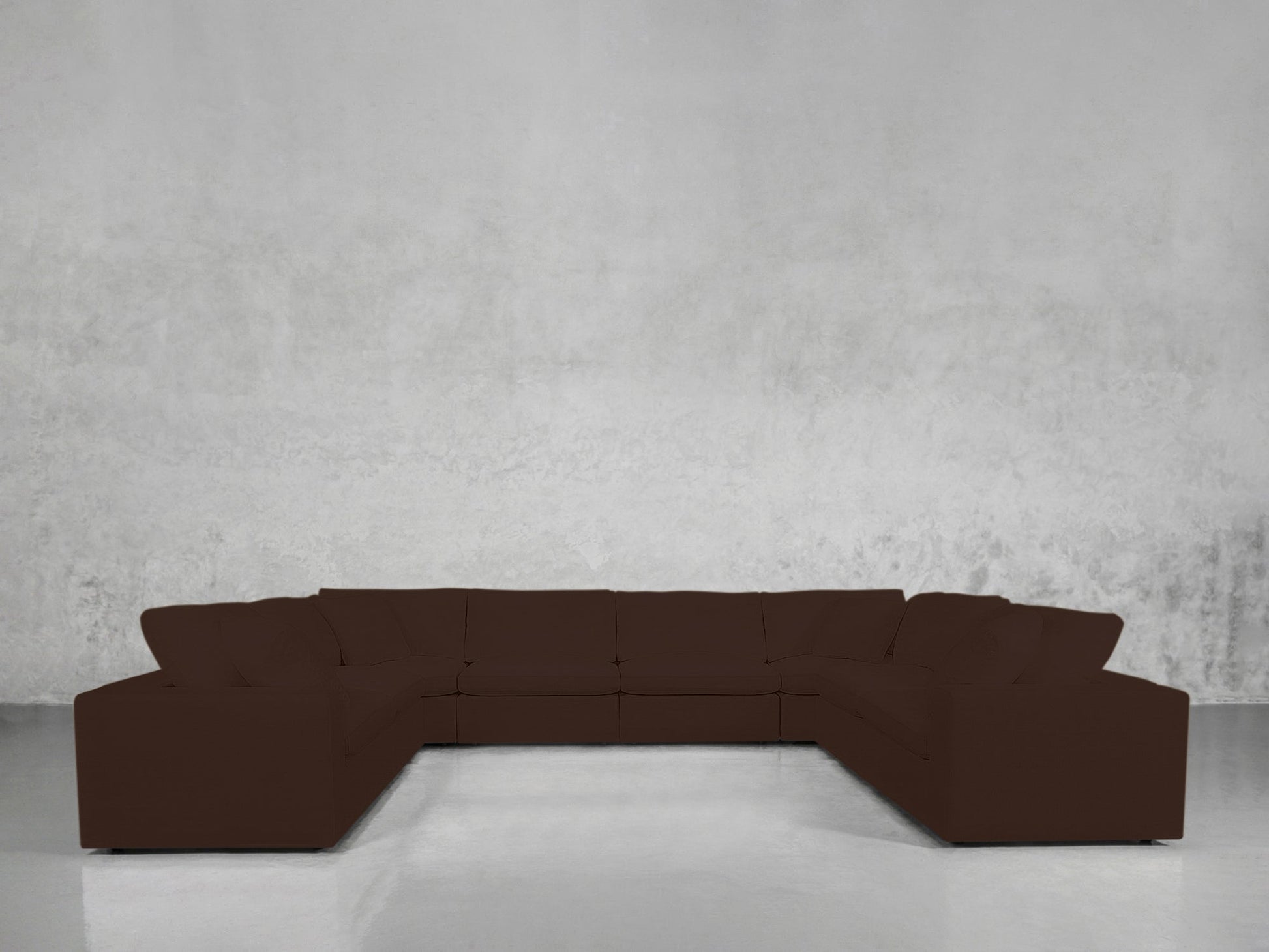 An 8-Seat Modular U-Sectional in dark brown is arranged in a U-shape against a plain, light gray textured wall and a shiny, reflective floor.