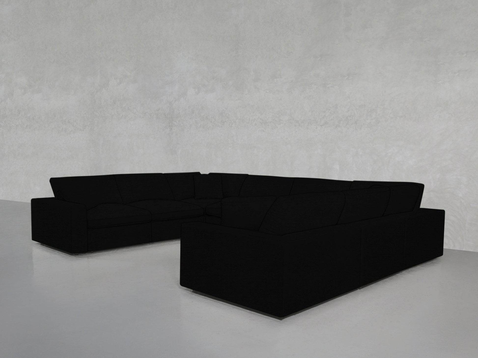 An 8-Seat Modular U-Sectional with plush cushions is placed on a glossy light gray floor against a textured light gray wall in a minimalist, modern room.
