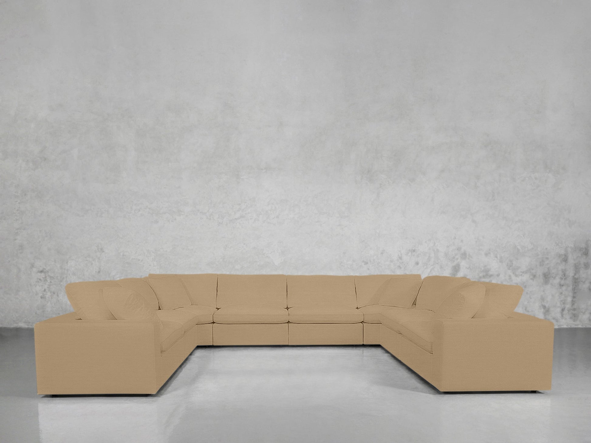 An 8-Seat Modular U-Sectional in beige with cushions is set against a plain light gray wall on a polished floor.
