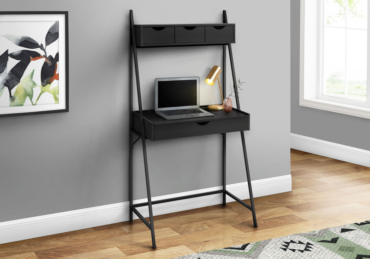 The Computer Desk For Home Office, featuring storage drawers and a shelf, holds a closed laptop, gold desk lamp, and plant. It stands against a gray wall beside a window with framed abstract art hanging nearby. Contemporary & modern design.
