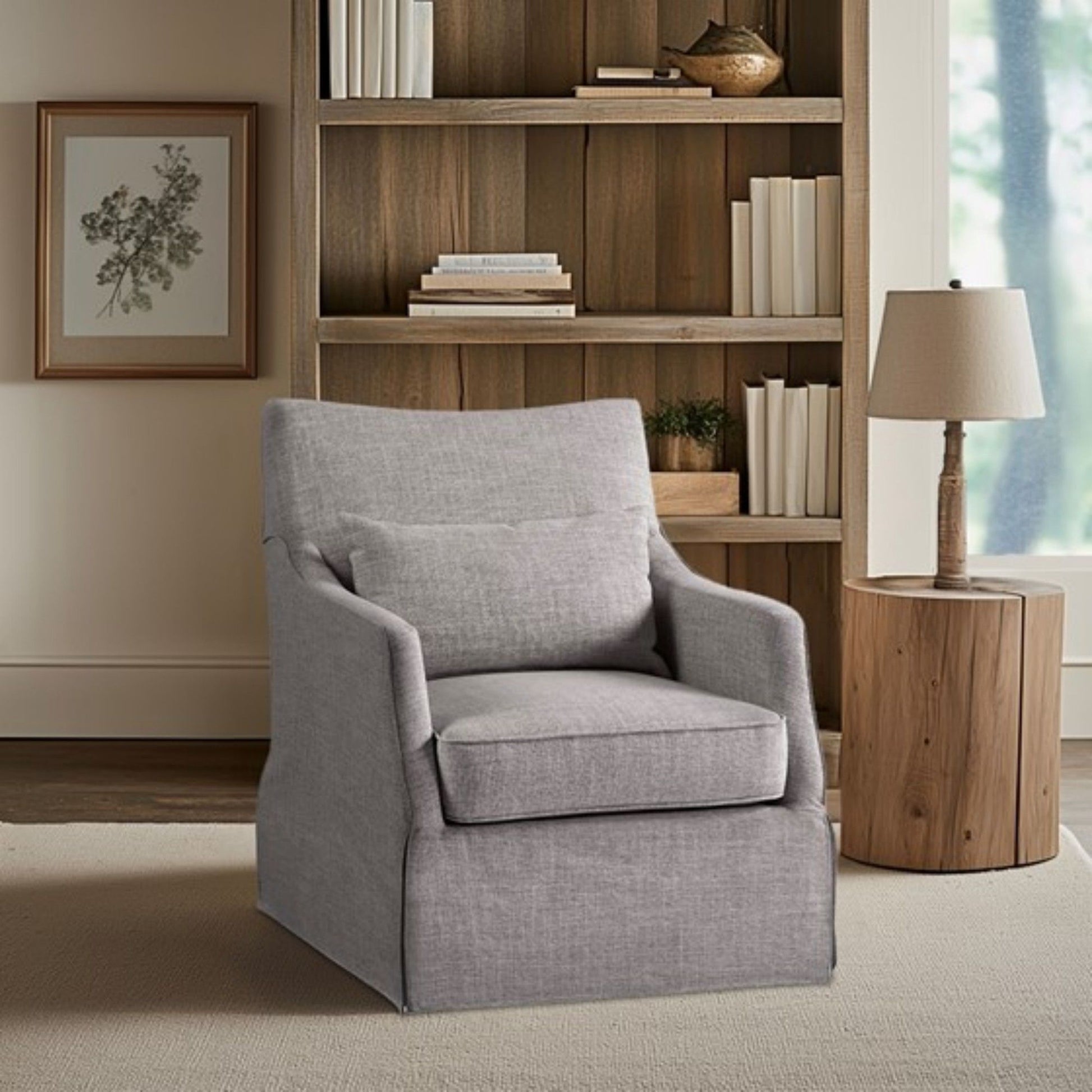 A modern living room featuring the Traditional Design London Skirted Swivel Chair in light gray upholstery, a wooden side table with a beige lamp, bookshelves with decor and books, and a framed botanical print on the wall.
