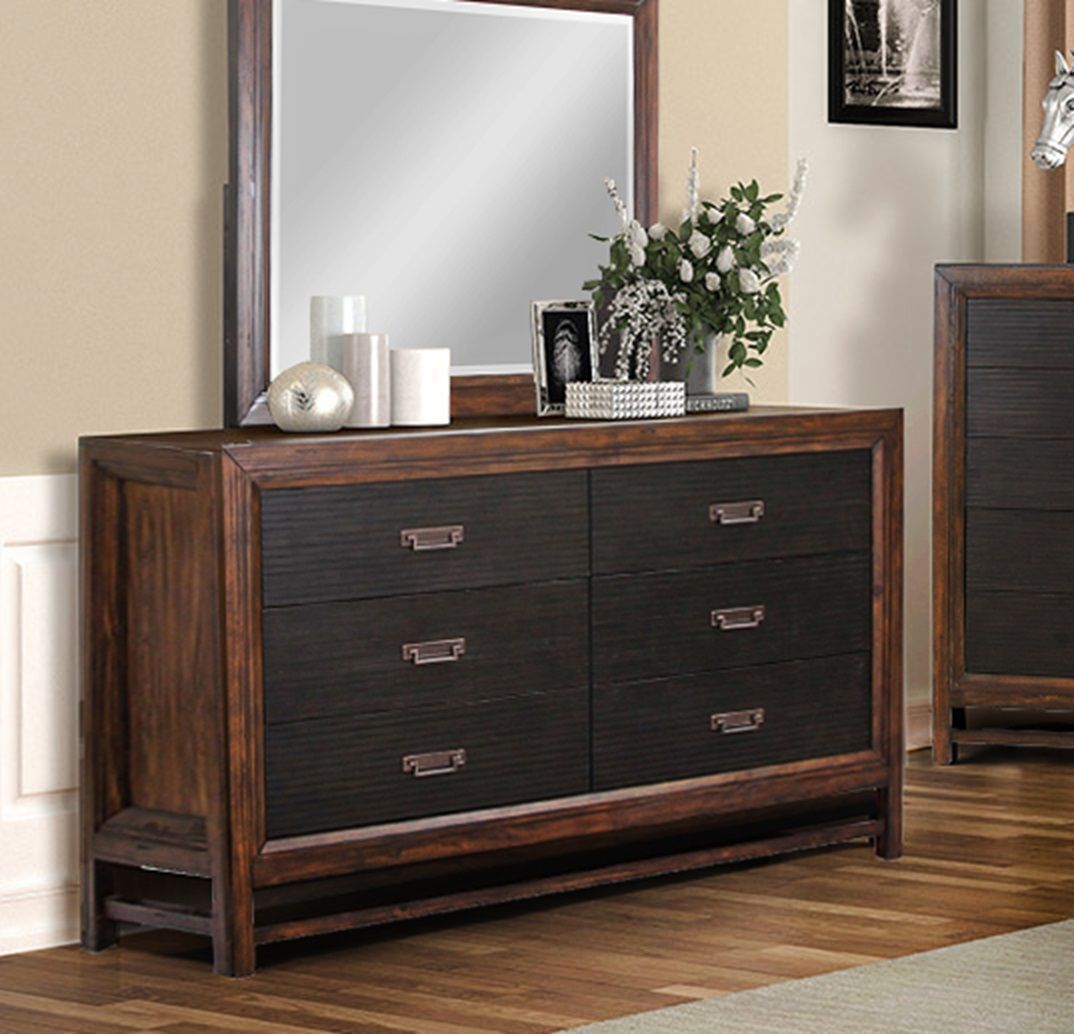 The Couch.com Branson 6 Drawer Dresser features a two tone brown wood design and dark brown finish. It sits against the wall topped with a mirror, vases, candles, and flowers on a wood floor beside a framed photo.