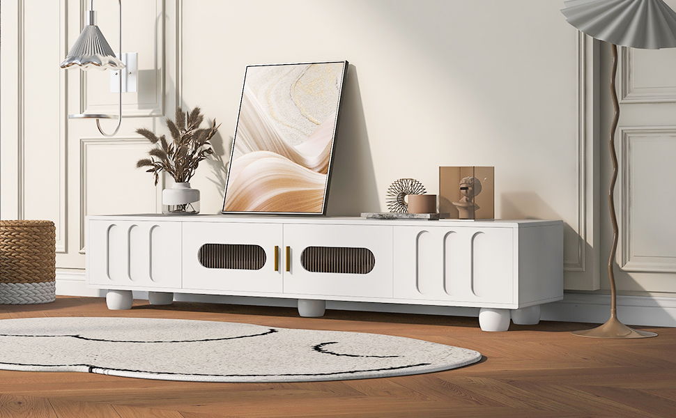 A modern living room featuring a Modern TV Stand for TVs up to 80" with glass door, drawers, and solid wood legs, complemented by abstract art, decorative objects, a floor lamp, a black-curve rug, wooden flooring, and minimalist neutral décor.