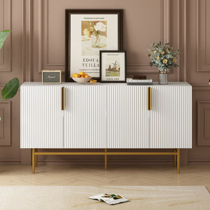 The Modern Elegant 4 Door Sideboard Gold Metal Handle Buffet Cabinet stands against a brown paneled wall, topped with framed art, flowers, a bowl of oranges, and a book; an open magazine lies on the floor beside it.