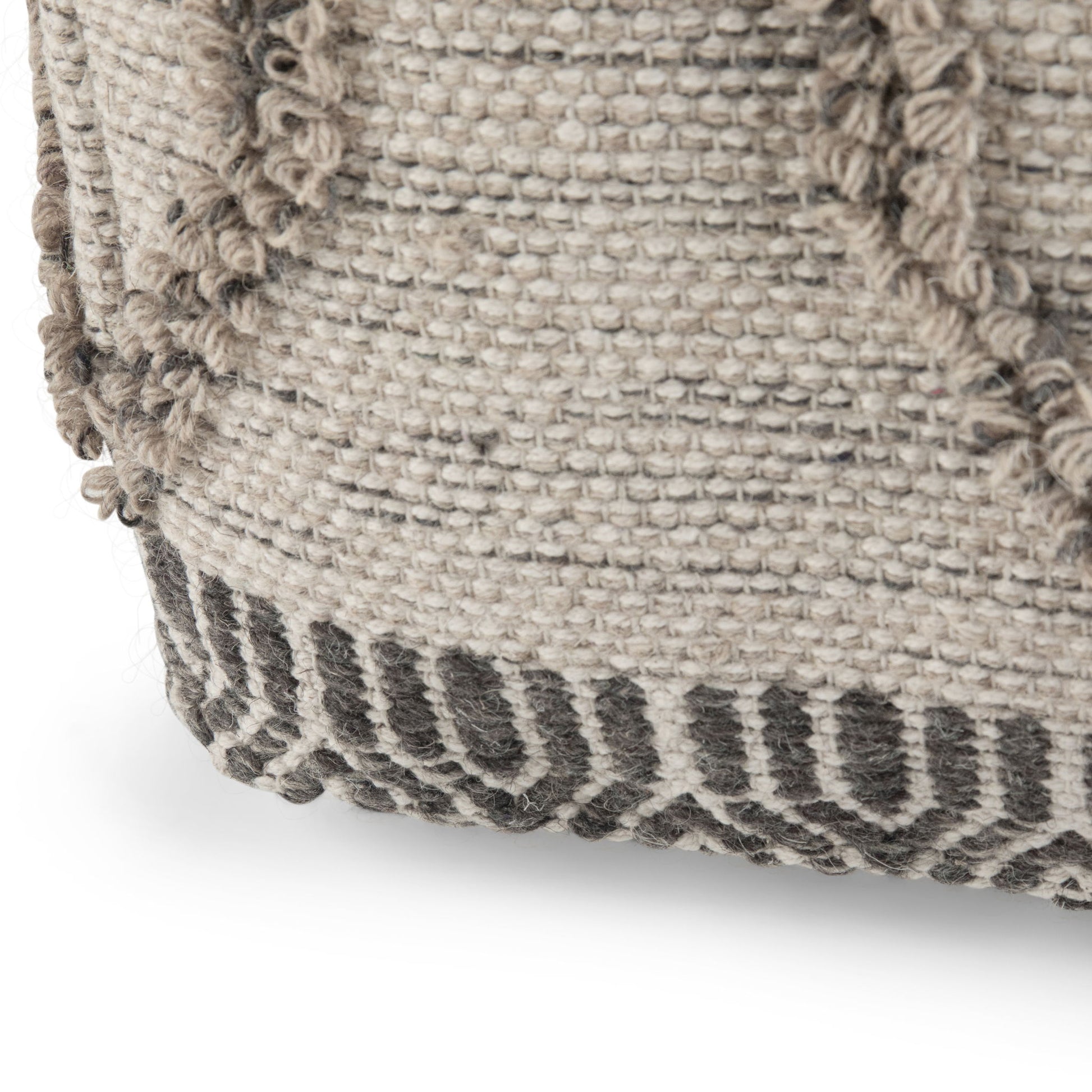 Close-up of the Sweeney Upholstered Square Pouf, showing its woven fabric in neutral tones with a textured, raised pattern and a dark geometric border at the base.