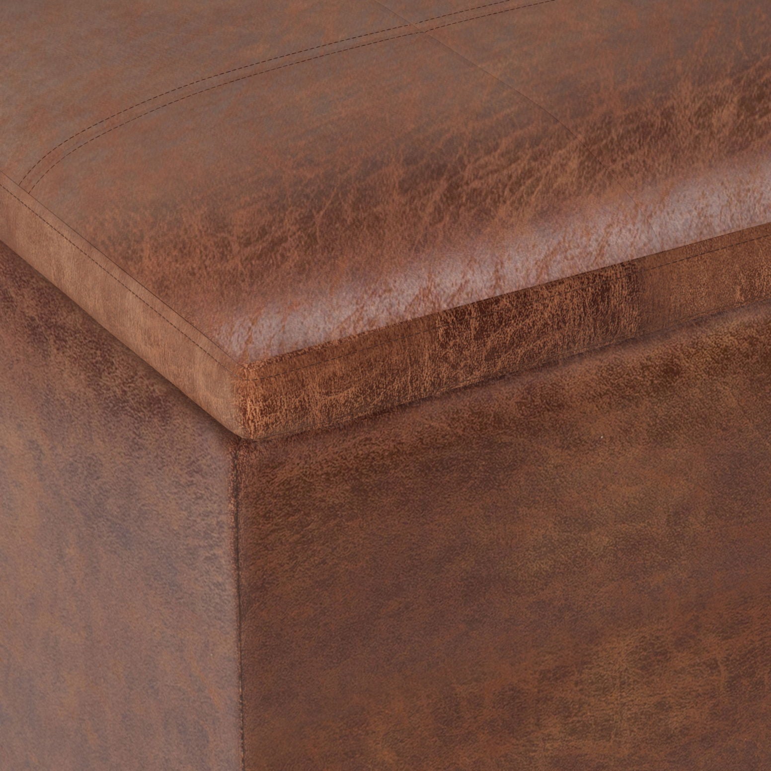 Close-up view of the Rockwood - Upholstered Cube Storage Ottoman With Tray, highlighting its brown leather texture, detailed stitching, and corner craftsmanship.