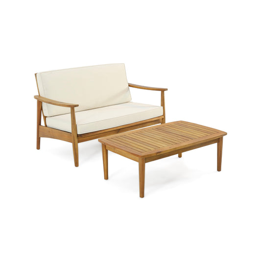 The Outdoor Acacia Wood Loveseat Set With Coffee Table features a wooden loveseat with cream cushions and a matching slatted coffee table in a simple modern design, displayed against a plain white background.