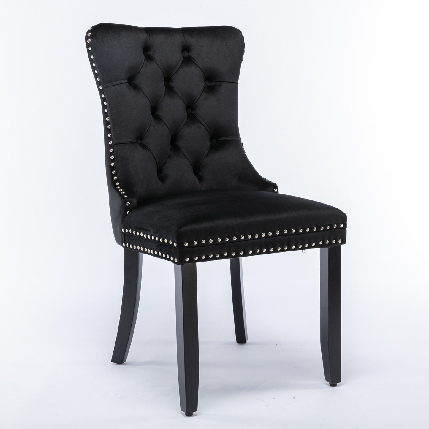 The Nikki set features two modern, high-end dining chairs with black velvet upholstery, tufted backs, silver nailhead trim, and solid wood legs, showcased against a plain white background.