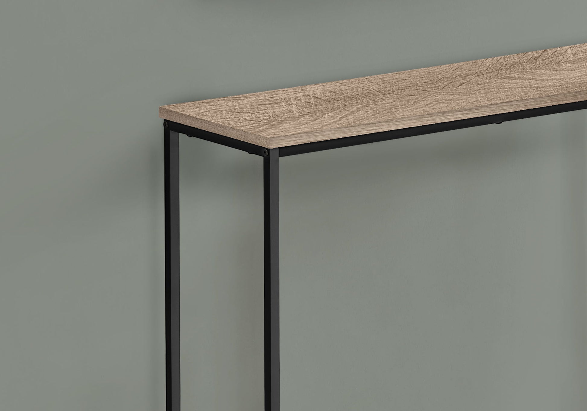 The Accent Console Table For Entryway, featuring a light wood top and slim black metal legs, is shown against a plain gray wall with only its corner visible, highlighting its contemporary and modern design with stable support.