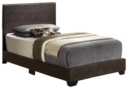 The Elegant Platform Bed For Relaxed Spaces features a dark brown leather frame, grey bedding, a beige blanket, and several decorative pillows in grey, beige, and patterned designs on top.