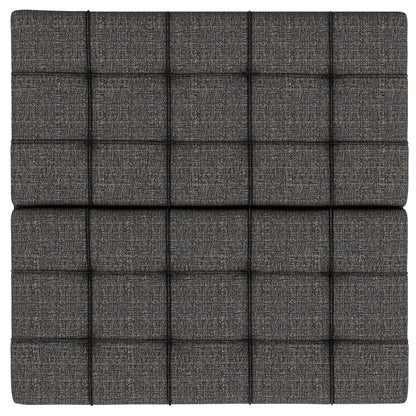 The Harrison Upholstered Coffee Table Storage Ottoman features a dark gray surface with evenly spaced, raised square padded sections for a modern tufted look.