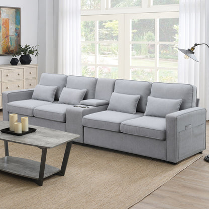 A modern living room with a large light gray Upholstered Sofa with console, 2 cupholders, 2 USB ports (wired/wireless charging), linen fabric and 4 pillows, paired with a wooden coffee table, beige rug, floor lamp, and big windows filling the space with natural light.
