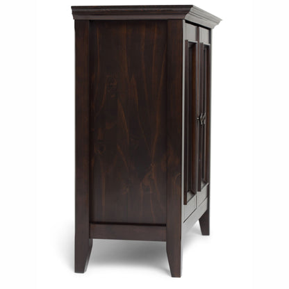 Side view of the Amherst - Handcrafted Low Storage Cabinet in dark wood, featuring paneled sides, raised legs, and two closed doors with metal handles, set against a plain white background.