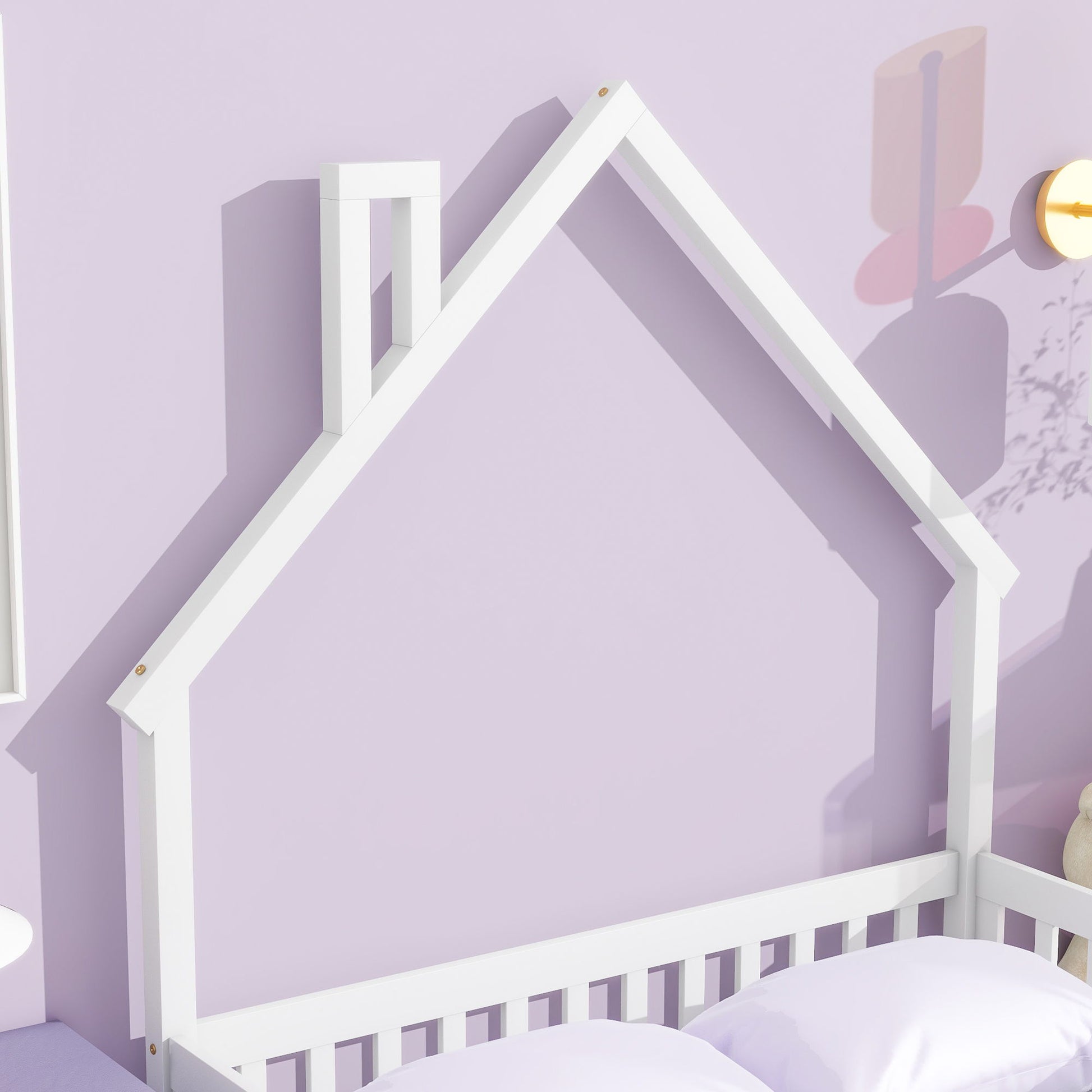 The House-Shaped Headboard Floor Bed With Fence, featuring a simple house design with chimney, stands against a light purple wall beside a round light fixture and colorful wall art for a playful, cozy bedroom.