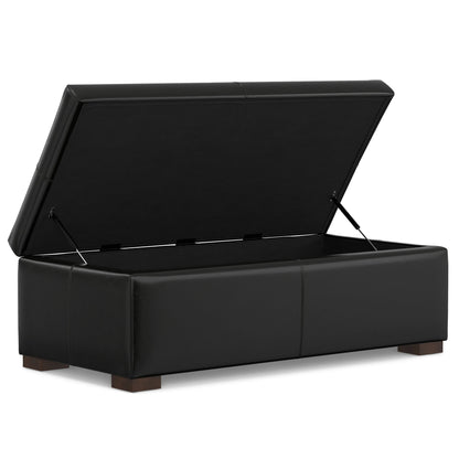 The Gabbie Coffee Table Upholstered Storage Ottoman features a black rectangular design with a hinged lid revealing an empty interior, a smooth surface, and four short wooden legs.