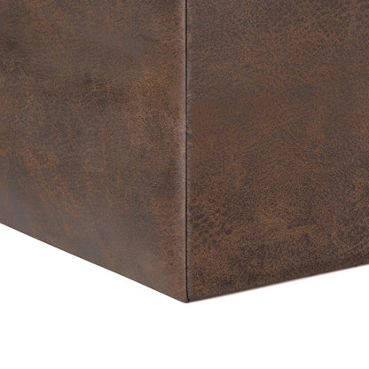 Close-up of the corner of the Rockwood Upholstered Cube Storage Ottoman With Tray, featuring a brown leather-textured finish and visible seams, shown against a white background.