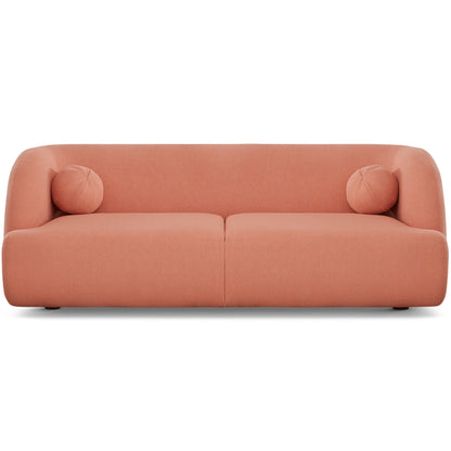 The Anna - French Boucle Sofa is a modern, minimalist piece in muted pink with smooth rounded edges and two matching cylindrical bolster pillows at each end.