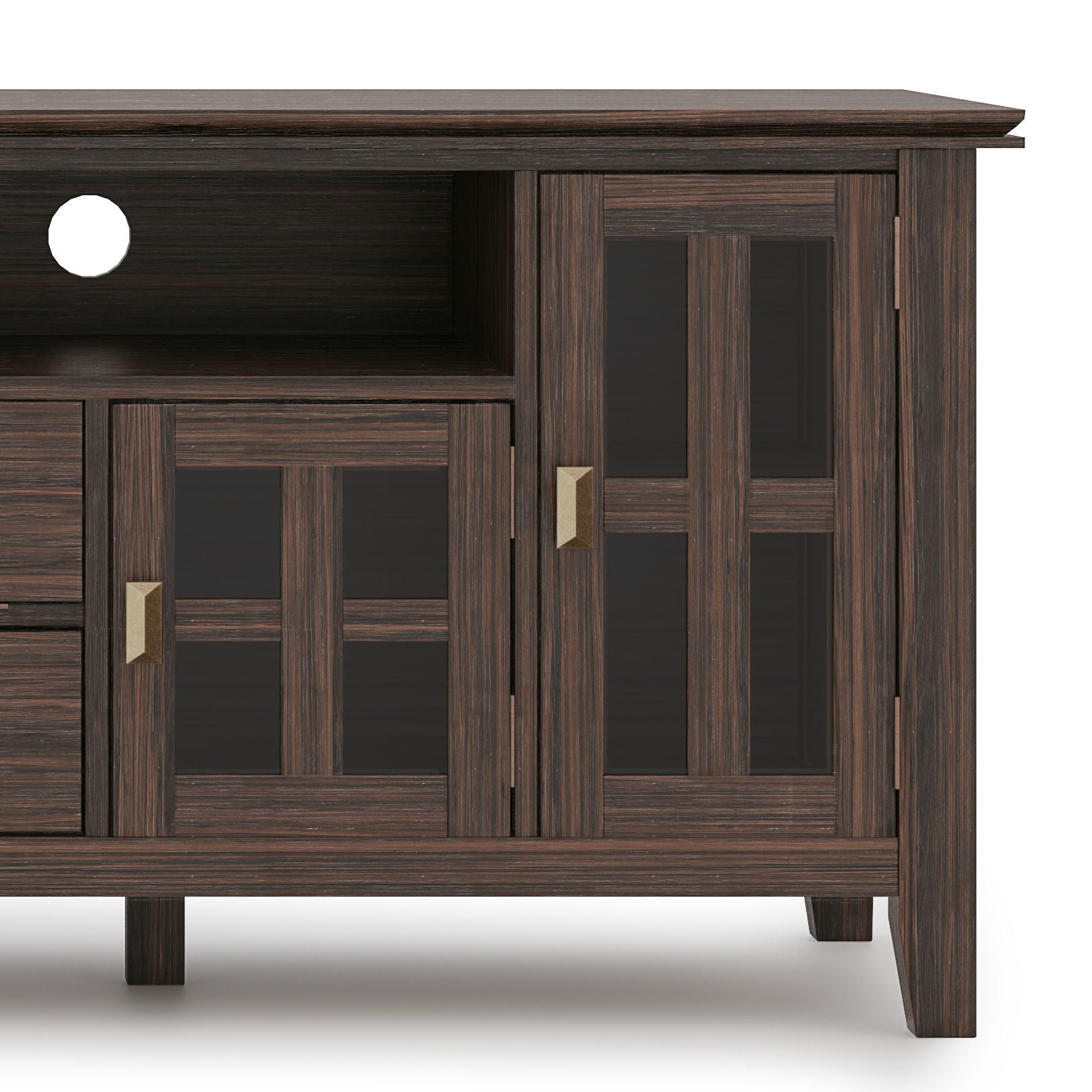 A close-up of the Artisan - TV Media Stand featuring dark wood, glass panel cabinet doors, brass handles, an open shelf, and a circular cable management hole at the back.