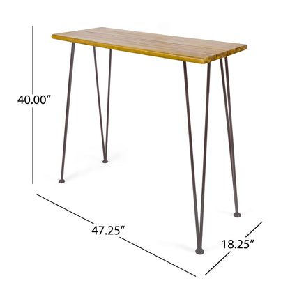 The Outdoor Bar Table features a teak wood tabletop with slim black iron hairpin legs. It measures 40" tall, 47.25" wide, and 18.25" deep.