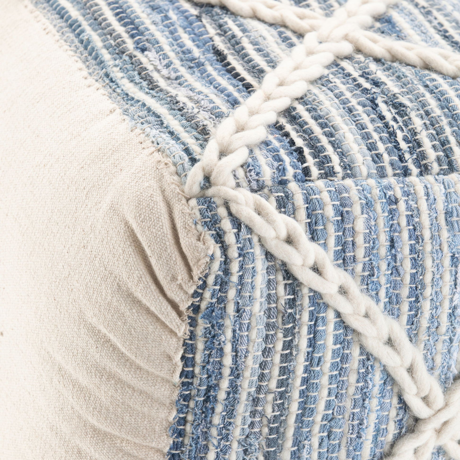 Close-up of the Cowan Handcrafted Square Pouf, featuring textured fabric with woven blue and white stripes, cream sides, and a thick cream braided accent across the surface.