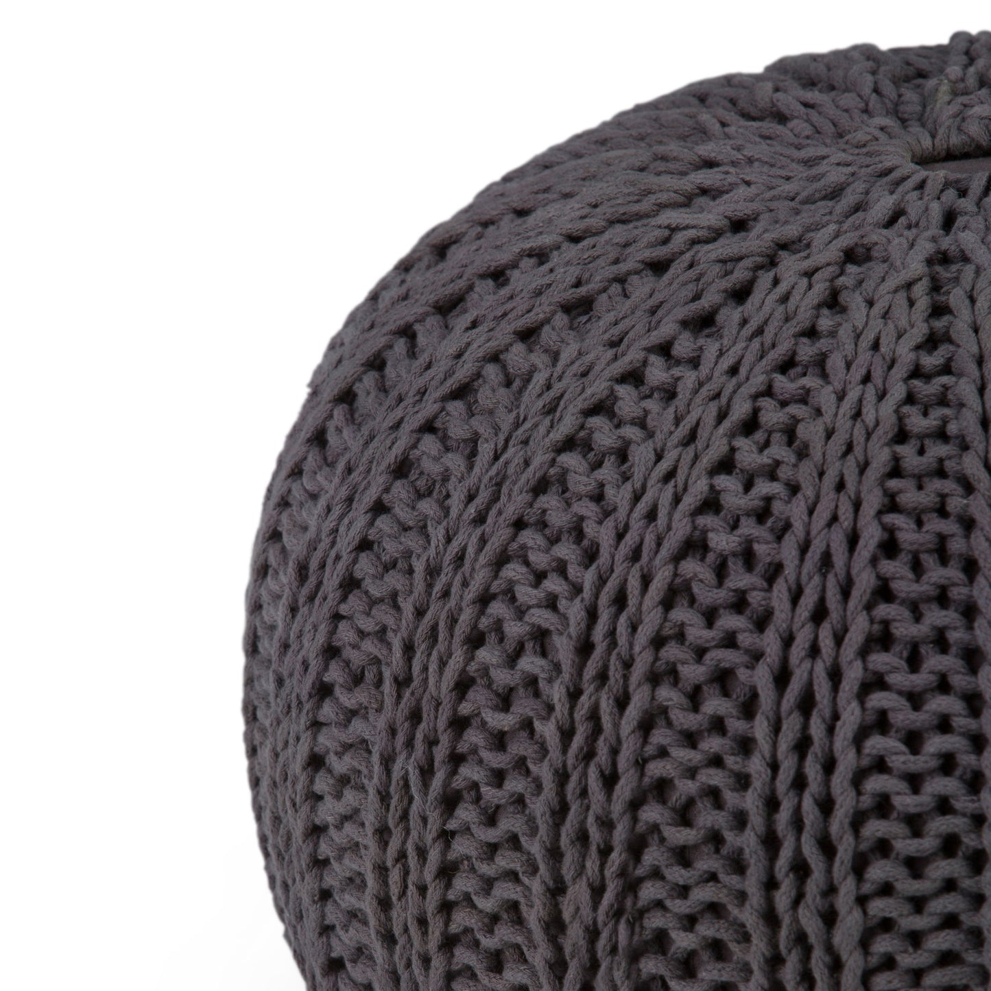 Close-up of the Shelby - Handcrafted Hand Knit Round Pouf in dark gray, featuring thick yarn and a textured ribbed pattern, partially visible against a white background.