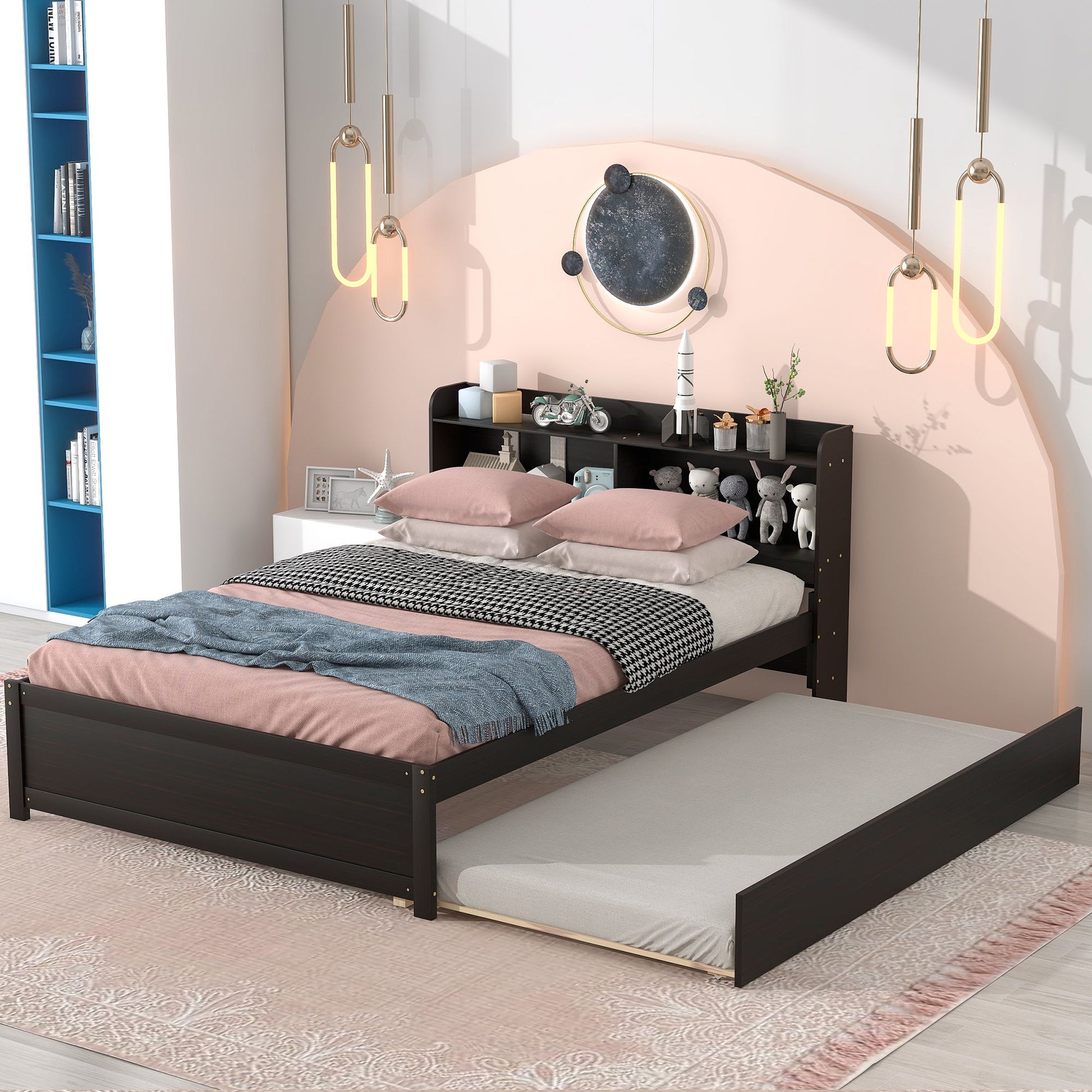 A modern bedroom with the Full Bed With Trundle, Bookcase in dark wood, light pink and gray bedding, a pull-out trundle, pendant lights, a round wall mirror, and white nightstands with decor.