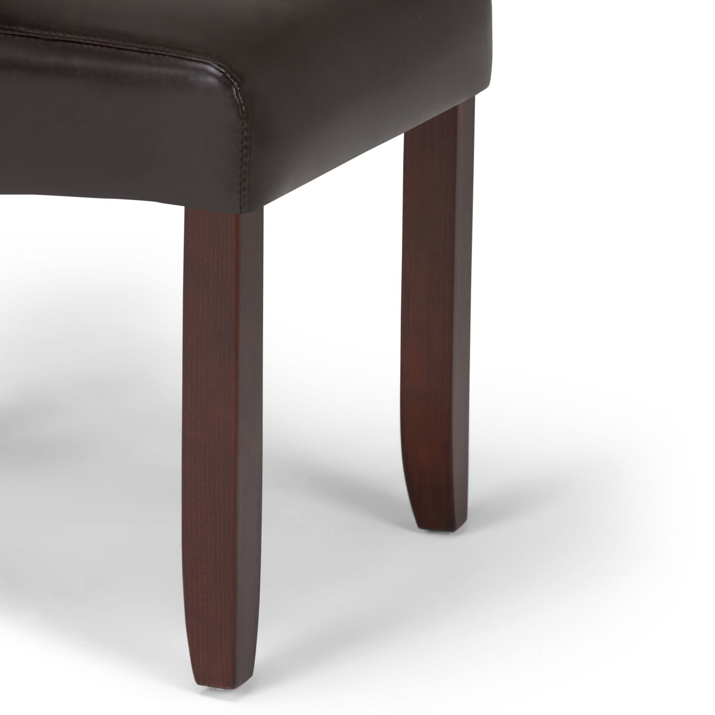 Close-up of the Cosmopolitan - Deluxe Tufted Parson Upholstered Chair, showcasing its dark brown wooden legs and dark leather or faux-leather seat against a white background.