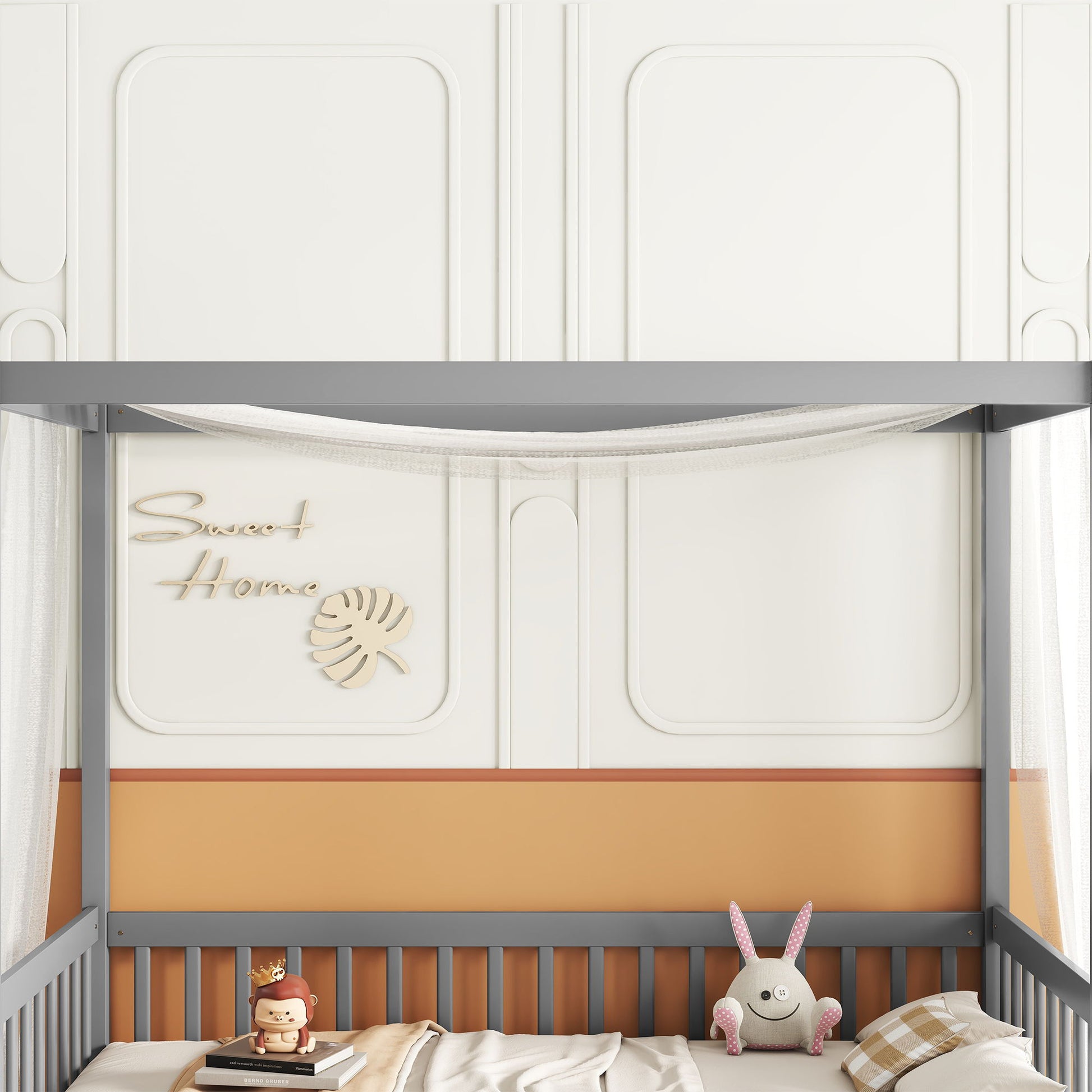 A cozy nursery featuring the Canopy Frame Floor Bed With Fence and Guardrails, paired with a plush lion toy, bunny stuffed animal, plaid bedding, "Sweet Home" leaf motif wall decor, and orange and white paneled walls.