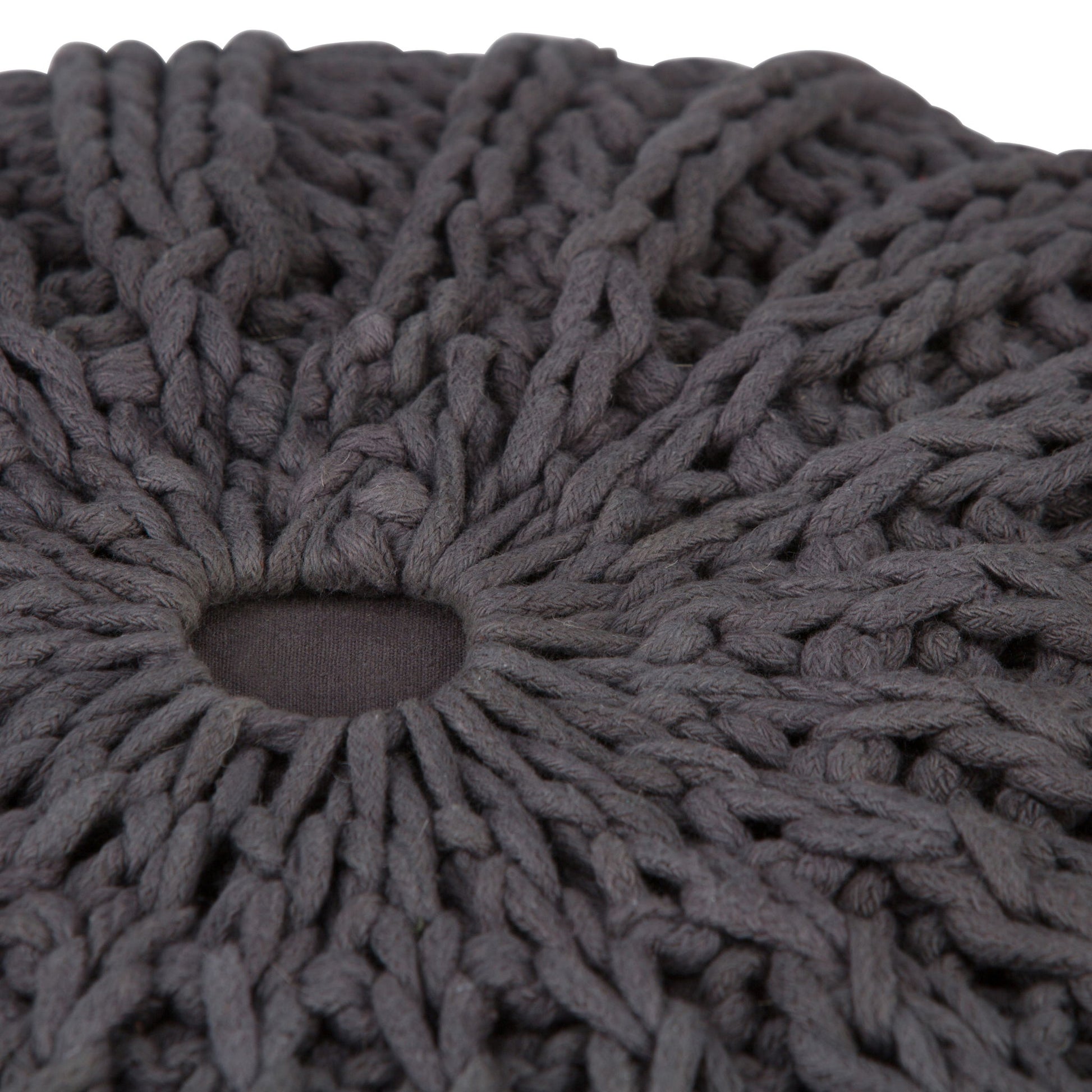 Close-up of the Shelby - Handcrafted Hand Knit Round Pouf, featuring thick, dark gray yarn with a small central hole that highlights the detailed texture and pattern of its knitted stitches.