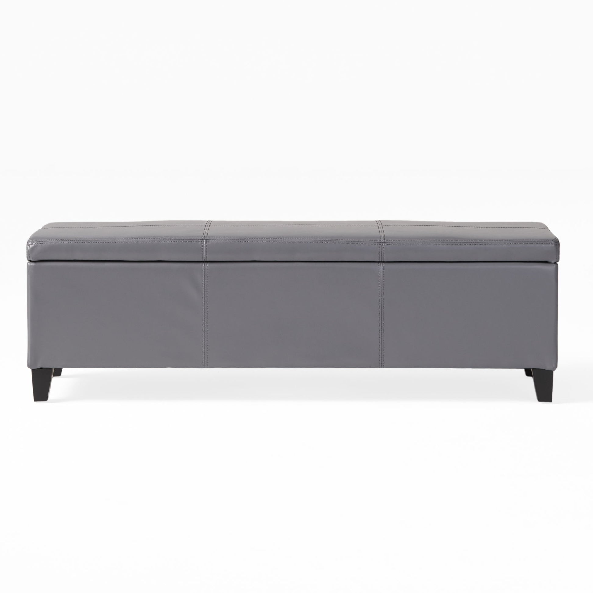 The Glouster - Contemporary Storage Ottoman features a rectangular gray design with a padded top, stitched details, and short black legs, shown against a plain white background.