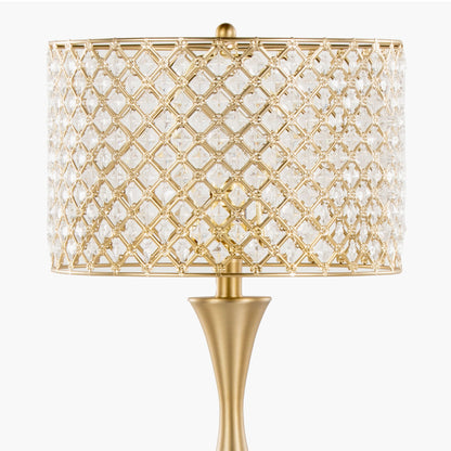 The Topaz - Contemporary Table Lamp features a gold, curved base and a decorative lattice-patterned crystal lampshade, displayed against a plain white background.