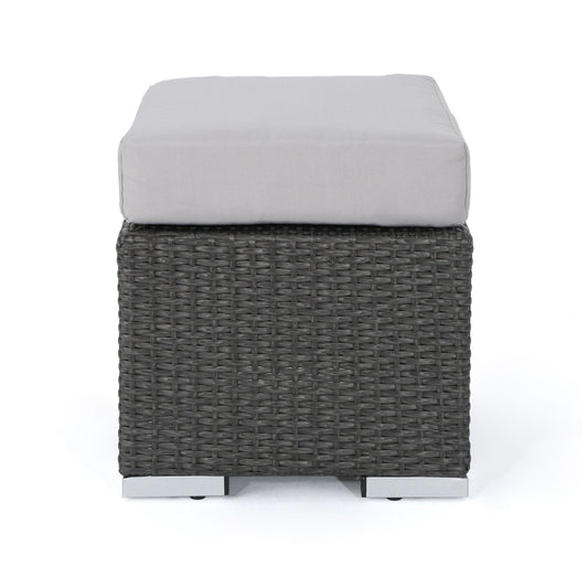The Santa Rosa - Outdoor Lounge Ottoman features a square design with a dark woven rattan base and a light gray cushioned top, displayed against a plain white background.