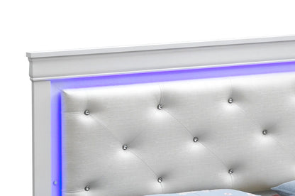 The Lorana - G6590C-FB3 Full Bed in Silver Champagne features a white tufted faux leather headboard with crystal-like buttons and a soft blue LED light strip along the top edge. The bed's lower portion is partially visible in the image.
