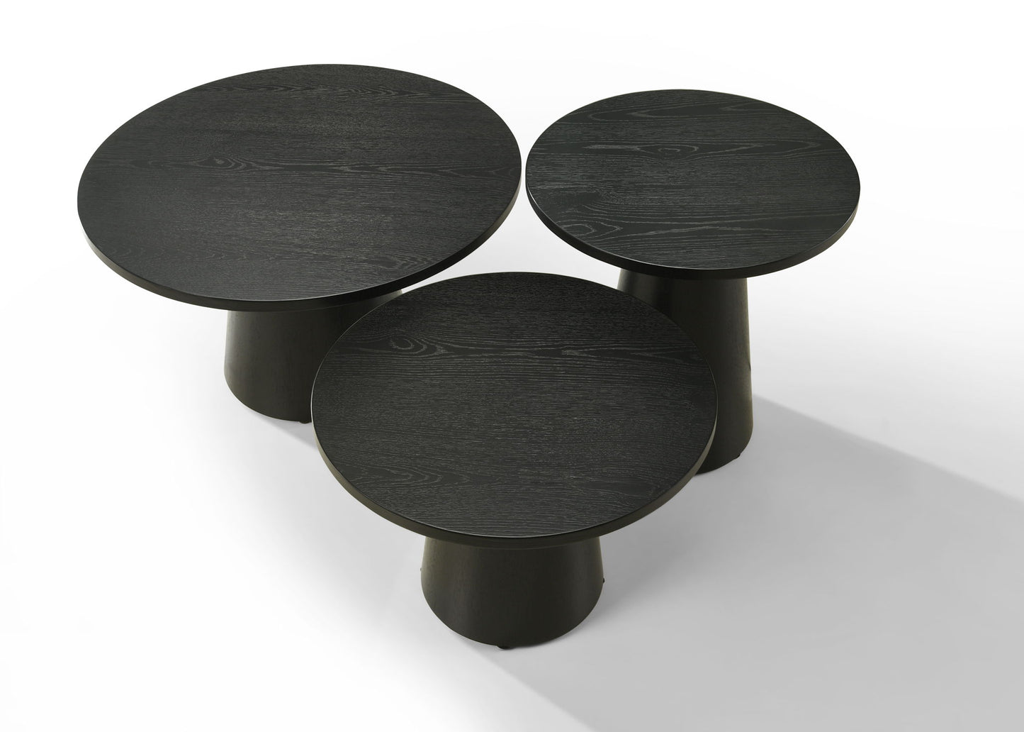 The Jasper 3 Piece Coffee, End, and Console Table Set in Ebony Black features three round wooden tables of different heights arranged together on a white background for a modern, minimalist look.