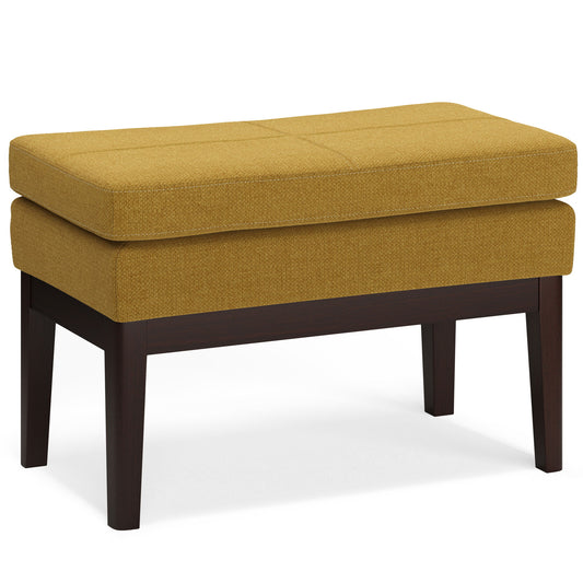 The Carlson - Ottoman Bench features a rectangular mustard yellow cushion, dark wooden legs, and a modern mid-century minimalist design. Shown against a white background.