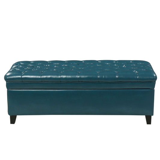 The Juliana Storage Ottoman features a teal tufted leather design, cushioned lift-up lid for hidden storage, and dark birch legs.