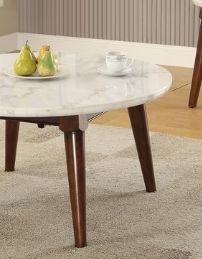 The Gasha Coffee Table in white marble with walnut legs displays two pears on a plate and a white teacup, set atop a light-colored carpet in a cozy, modern room.