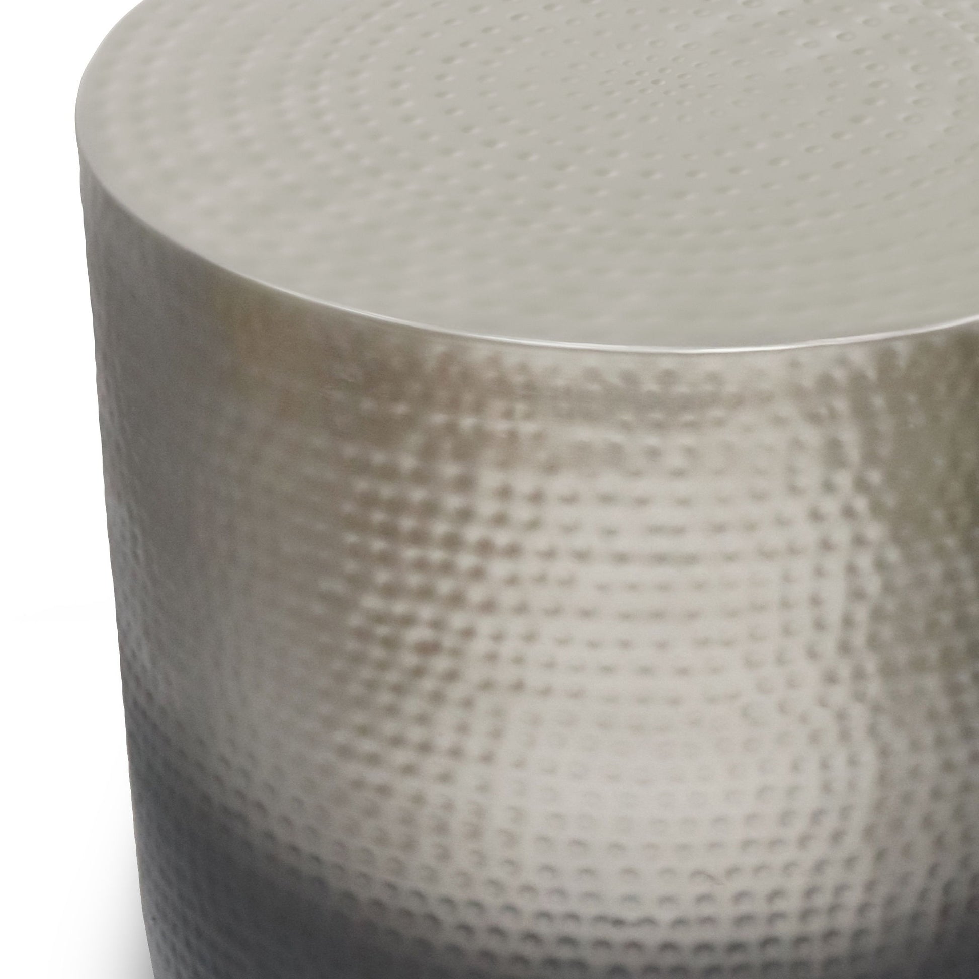 A close-up view of the Nova - Handcrafted Metal Side Table, featuring a round, metallic silver design with a hammered, textured surface.