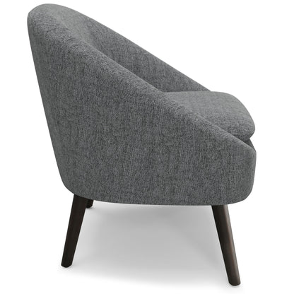 The Redding - Upholstered Accent Chair features a modern gray design with a rounded backrest and dark wooden legs, displayed from a side angle against a white background.