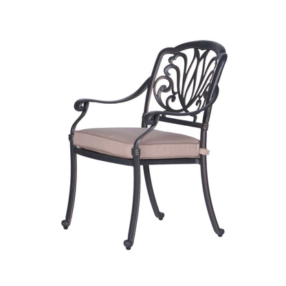 The Square 8 Person 64" Long Aluminum Dining Set With Cushions features black metal armchairs with ornate curved backrests and beige cushioned seats, displayed at an angle against a white background.