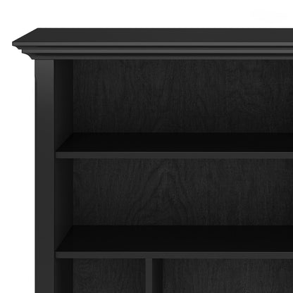 A close-up of the Amherst - Multi Cube Bookcase and Storage Unit in black wood, featuring two shelves with simple, clean lines and a slightly decorative top edge. The shelves are empty.