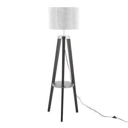 The Compass - Mid Century Modern Floor Lamp With Shelf features a white drum shade, black tripod legs, a round base shelf, and a black power cord that extends to the floor.