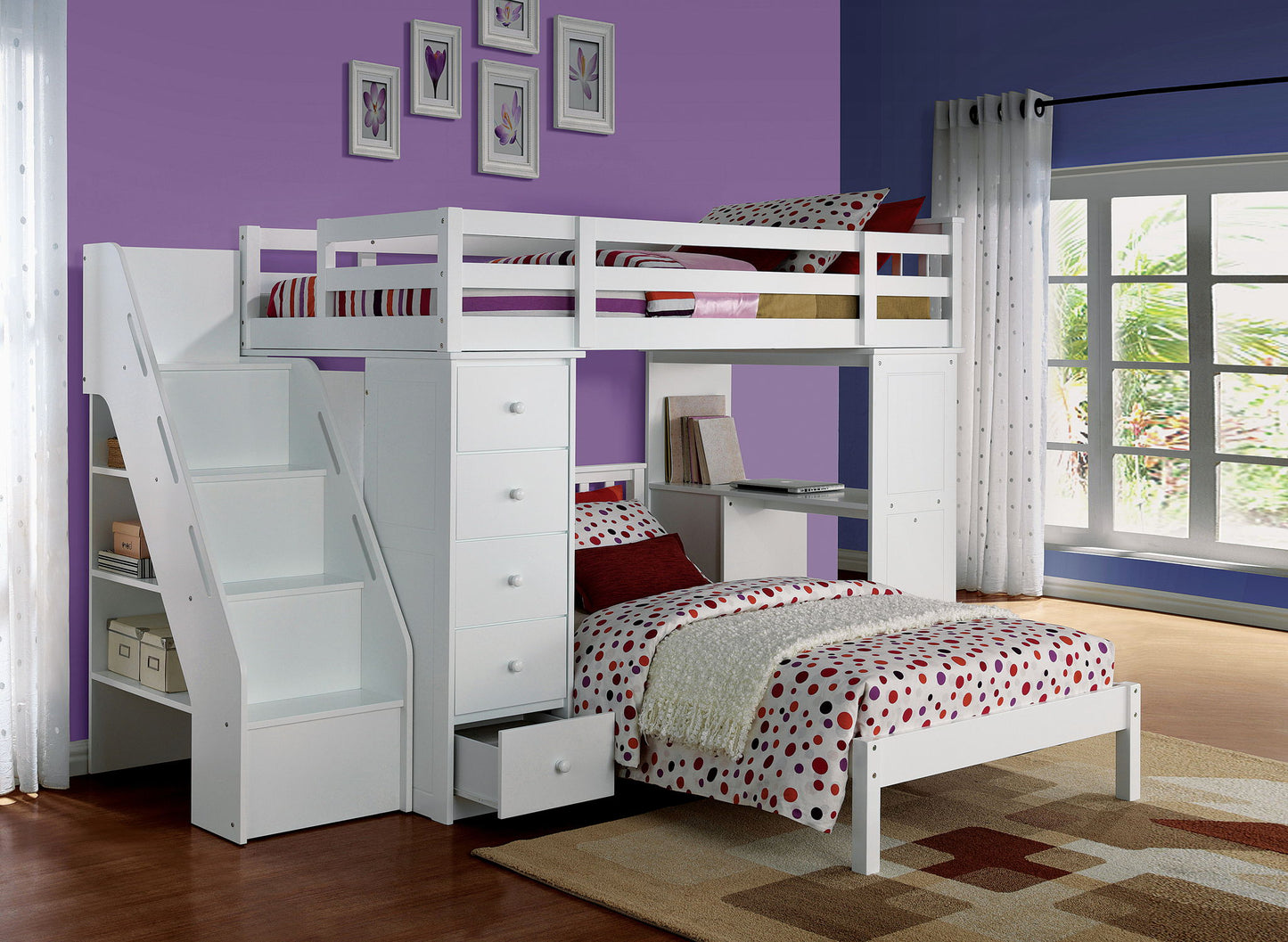 A modern bedroom with purple walls features the Freya Twin Loft Bed With Storage in white, complete with stairs, drawers, and a desk. A window with sheer curtains and framed art decorate the space. The bedding is red and white polka dots.