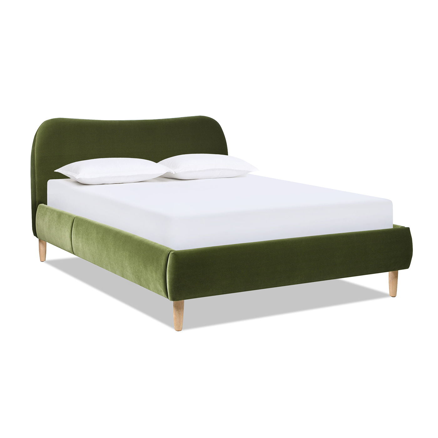 The Roman - Curved Headboard Upholstered Platform Bed features green velvet upholstery, light wooden legs, a curved headboard, and a low-profile footboard. Shown with a white mattress and two white pillows.